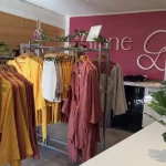 Portant de vêtements en lin dans le showroom Diane G