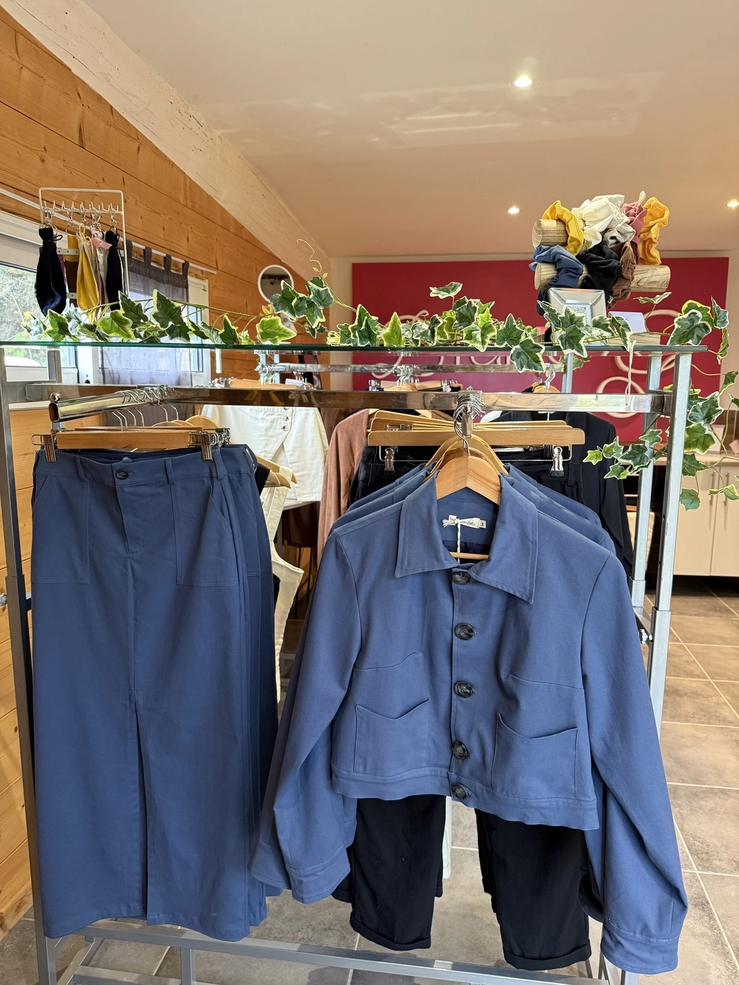 Portant avec vêtements bleus en showroom Diane G